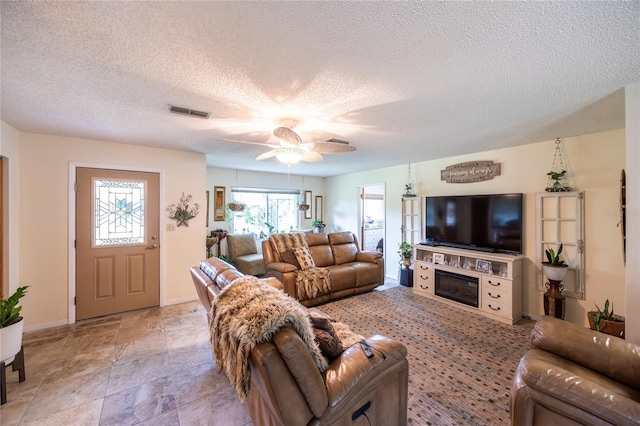 261 Ishie Ave, Bronson, FL 32621 - living room featuring ceiling fan, a glass covered fireplace, and a textured ceiling