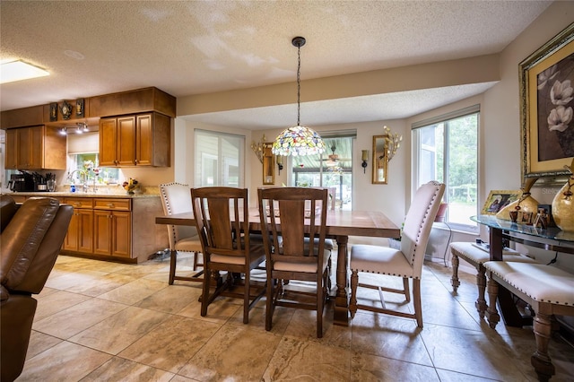 261 Ishie Ave, Bronson, FL 32621 - dining area with a textured ceiling, light tile patterned flooring, and a chandelier