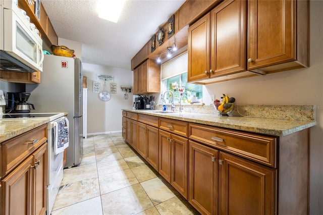 261 Ishie Ave, Bronson, FL 32621 - kitchen featuring white appliances, brown cabinets, and light stone countertops