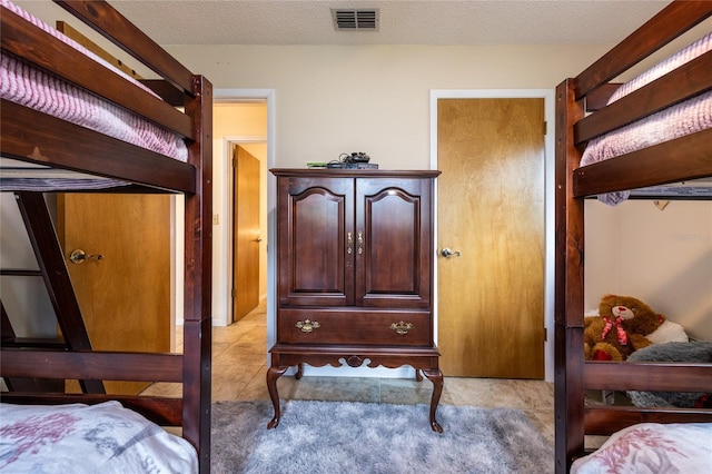 261 Ishie Ave, Bronson, FL 32621 - bedroom featuring light tile patterned flooring and a textured ceiling