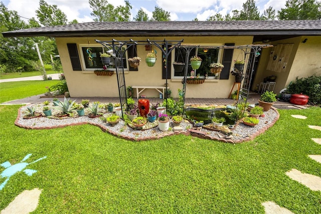 261 Ishie Ave, Bronson, FL 32621 - rear view of property with stucco siding, a yard, and roof with shingles