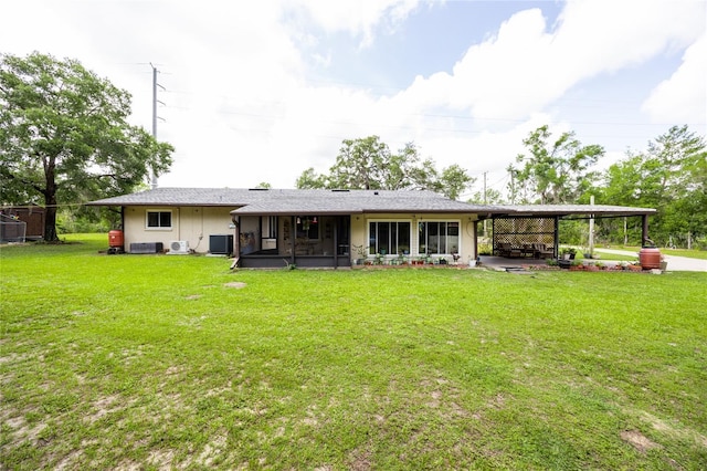 261 Ishie Ave, Bronson, FL 32621 - back of house with a sunroom, a lawn, and an attached carport