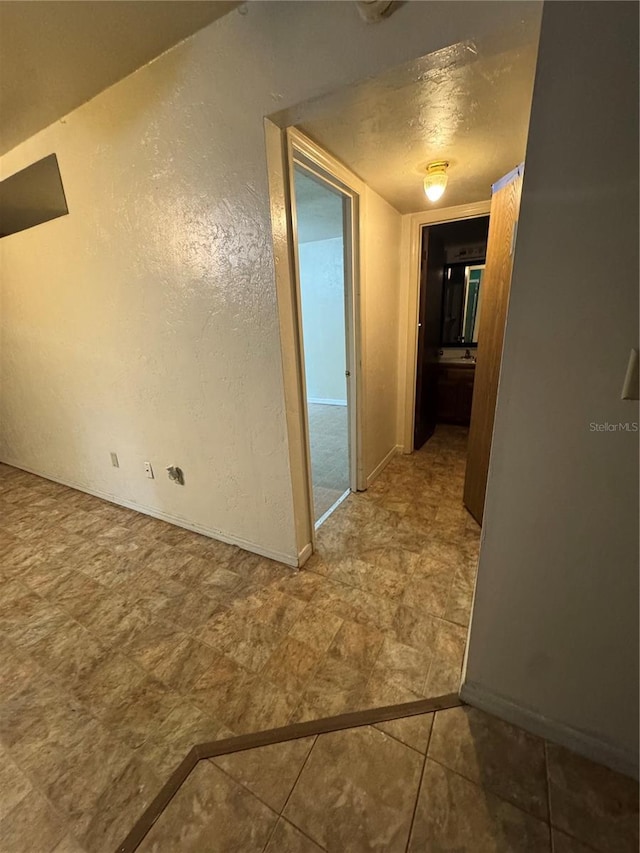 1515 NW 29th Rd Unit E3, Gainesville, FL 32605 - corridor with a textured wall and baseboards