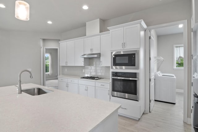 3520 SW 120th Dr, Gainesville, FL 32608 - kitchen featuring stainless steel appliances, independent washer and dryer, under cabinet range hood, healthy amount of natural light, and recessed lighting
