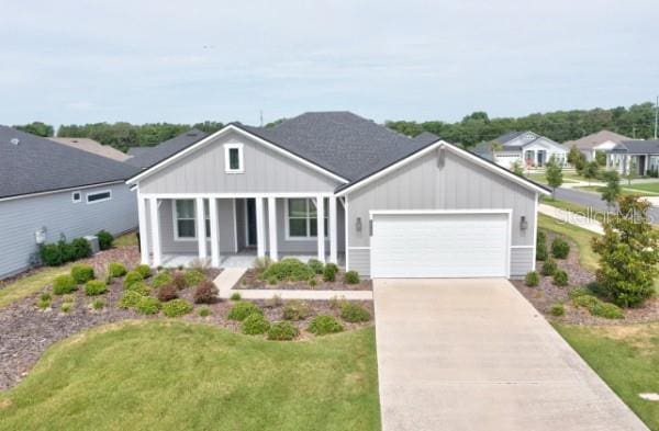 3520 SW 120th Dr, Gainesville, FL 32608 - ranch-style home featuring board and batten siding, covered porch, an attached garage, driveway, and a front yard