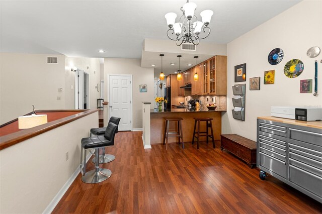 5328 NW 9th Ln, Gainesville, FL 32605 - kitchen with brown cabinets, a breakfast bar, dark wood-style floors, and recessed lighting