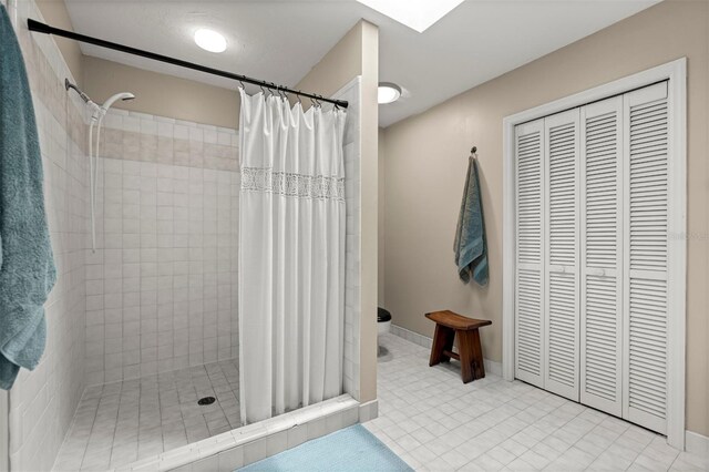 5328 NW 9th Ln, Gainesville, FL 32605 - full bathroom featuring tiled shower, toilet, a closet, and baseboards