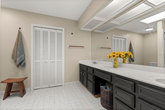 5328 NW 9th Ln, Gainesville, FL 32605 - full bathroom with double vanity, toilet, baseboards, and a closet