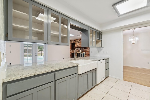 2626 NW 36th Pl, Gainesville, FL 32605 - kitchen featuring gray cabinets, white dishwasher, light tile patterned floors, and glass insert cabinets