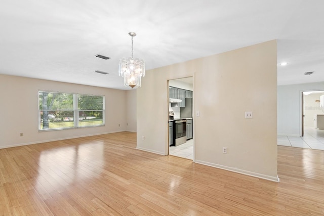 2626 NW 36th Pl, Gainesville, FL 32605 - empty room featuring a chandelier and light wood-type flooring