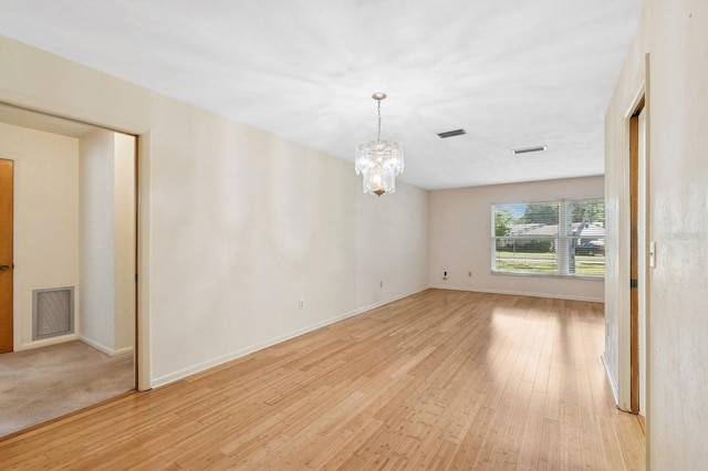 2626 NW 36th Pl, Gainesville, FL 32605 - empty room with a chandelier and light wood-style floors