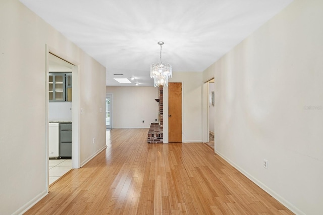 2626 NW 36th Pl, Gainesville, FL 32605 - empty room featuring a chandelier and light wood-style flooring