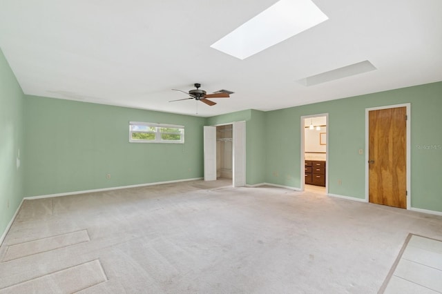2626 NW 36th Pl, Gainesville, FL 32605 - unfurnished bedroom featuring light carpet, a skylight, a ceiling fan, and ensuite bathroom