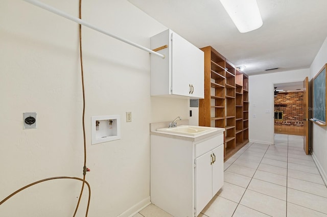 2626 NW 36th Pl, Gainesville, FL 32605 - laundry room featuring washer hookup, hookup for an electric dryer, cabinet space, light tile patterned floors, and a fireplace
