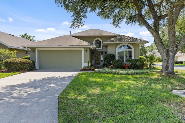 6033 NW 36th Dr, Gainesville, FL 32653 - view of front of house with stucco siding, a garage, a front lawn, and driveway