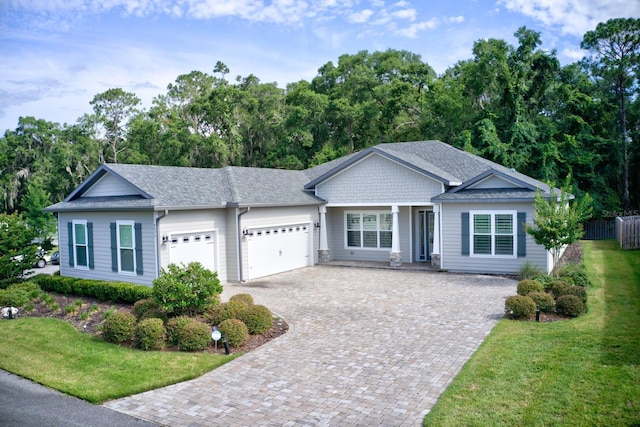 9474 SW 65th Pl, Gainesville, FL 32608 - ranch-style house with driveway, an attached garage, a front lawn, and roof with shingles