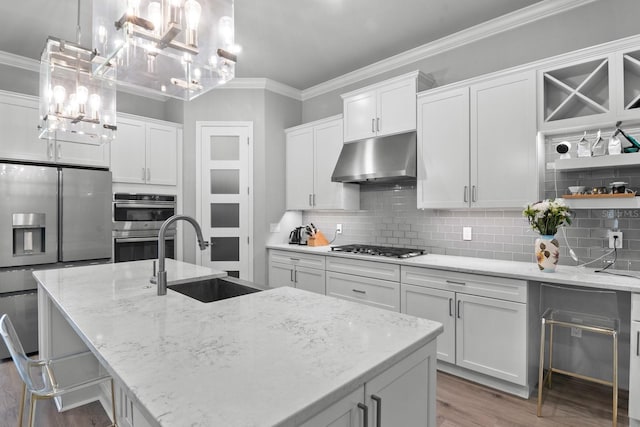 9474 SW 65th Pl, Gainesville, FL 32608 - kitchen with under cabinet range hood, crown molding, appliances with stainless steel finishes, a chandelier, and wood finished floors