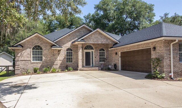 2361 Sandy Run Dr N, Middleburg, FL 32068 - view of front of property featuring brick siding, a garage, a shingled roof, and driveway