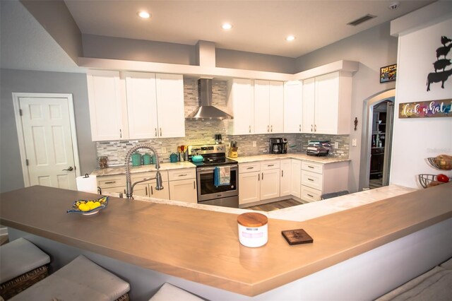 2361 Sandy Run Dr N, Middleburg, FL 32068 - kitchen with wall chimney range hood, stainless steel range with electric stovetop, a breakfast bar, tasteful backsplash, and white cabinets