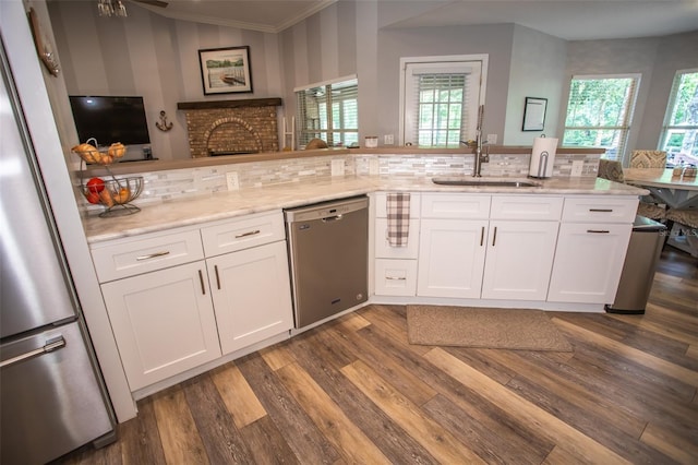 2361 Sandy Run Dr N, Middleburg, FL 32068 - kitchen with appliances with stainless steel finishes, light stone counters, dark wood-type flooring, white cabinets, and ornamental molding