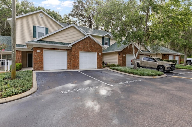13200 W Newberry Rd Unit T110, Newberry, FL 32669 - view of front of house with brick siding, a shingled roof, and uncovered parking