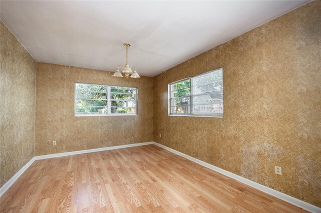 2147 NW 7th Pl, Gainesville, FL 32603 - spare room featuring light wood-type flooring, a chandelier, and healthy amount of natural light