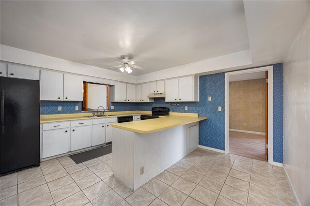 2147 NW 7th Pl, Gainesville, FL 32603 - kitchen featuring black appliances, light countertops, under cabinet range hood, a peninsula, and white cabinets