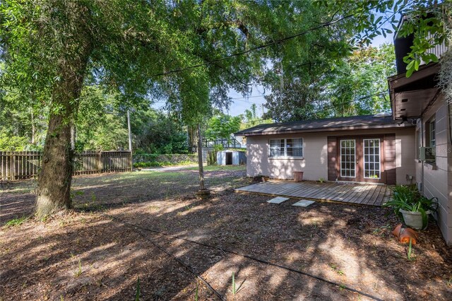 2147 NW 7th Pl, Gainesville, FL 32603 - fenced backyard featuring a wooden deck and a storage shed