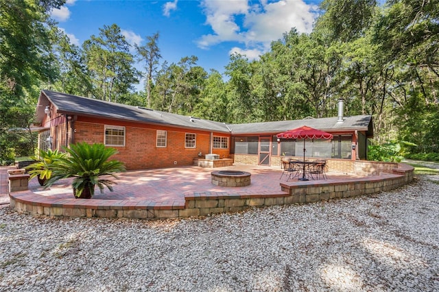 2809 SW 81st St, Gainesville, FL 32608 - rear view of house featuring a patio area, an outdoor fire pit, and brick siding