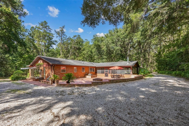 2809 SW 81st St, Gainesville, FL 32608 - view of front facade with a wooden deck, driveway, and a wooded view