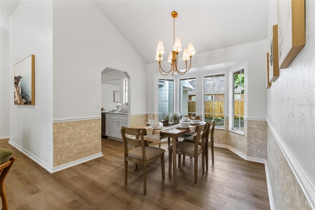 10943 NW 34th Pl, Gainesville, FL 32606 - dining room featuring wainscoting, wood finished floors, a chandelier, arched walkways, and high vaulted ceiling