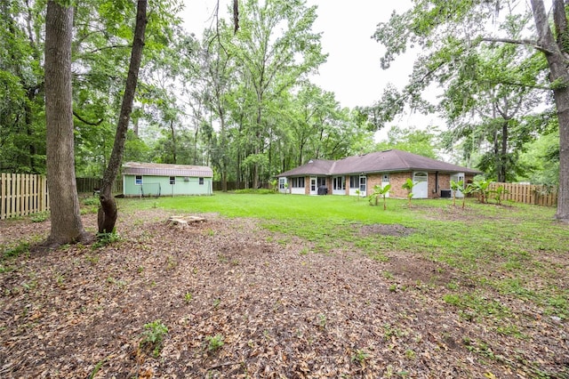 9911 NW 24th Pl, Gainesville, FL 32606 - fenced backyard featuring an outdoor structure and view of scattered trees