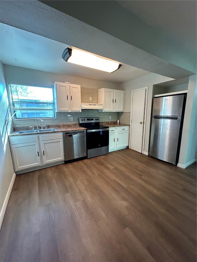 2811 SW Archer Rd Unit X203, Gainesville, FL 32608 - kitchen featuring stainless steel appliances, under cabinet range hood, dark wood-type flooring, white cabinets, and backsplash