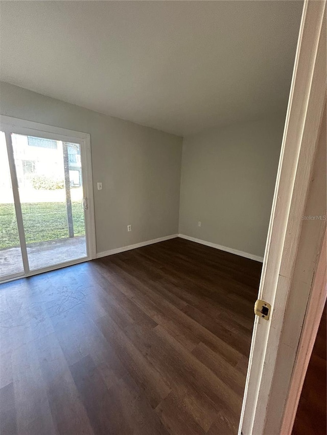 2811 SW Archer Rd Unit X203, Gainesville, FL 32608 - empty room featuring dark wood-type flooring and baseboards