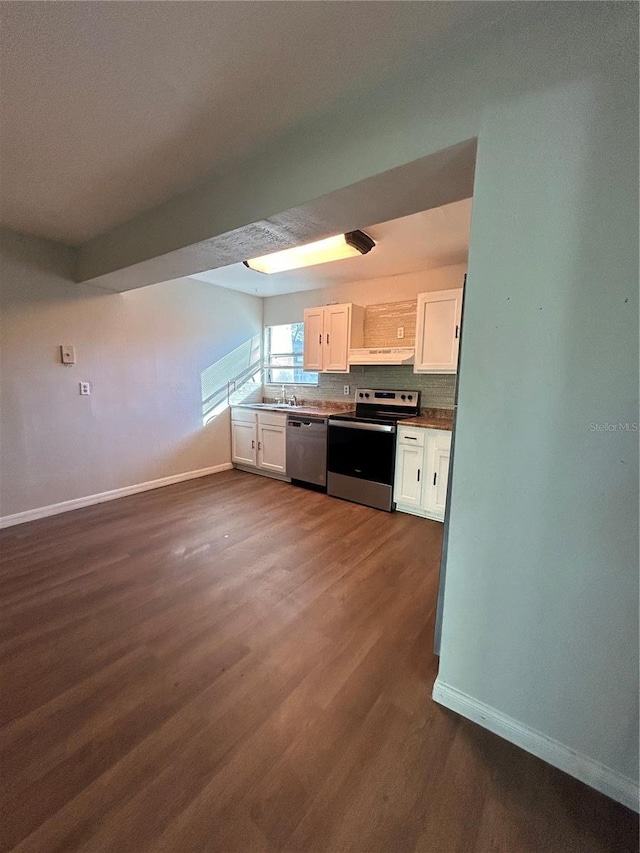 2811 SW Archer Rd Unit X203, Gainesville, FL 32608 - kitchen featuring appliances with stainless steel finishes, white cabinetry, under cabinet range hood, dark wood-style floors, and tasteful backsplash