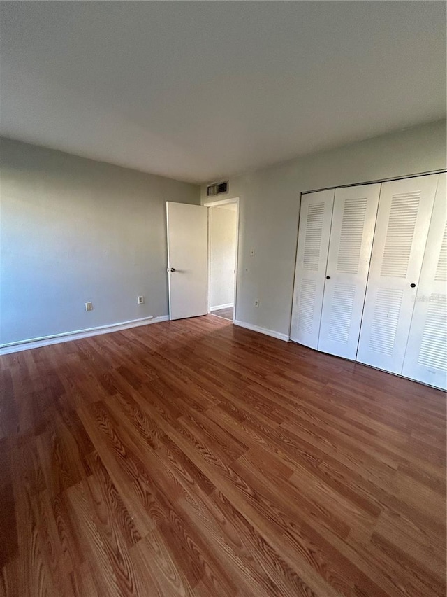 2811 SW Archer Rd Unit X203, Gainesville, FL 32608 - unfurnished bedroom with wood finished floors and a closet