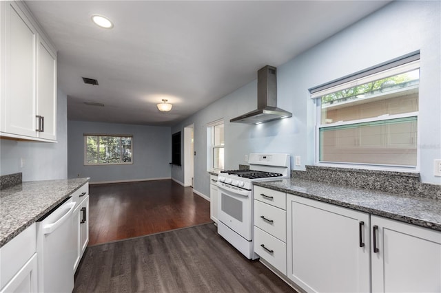 1814 NE 7th St, Gainesville, FL 32609 - kitchen featuring white appliances, wall chimney exhaust hood, dark wood-style flooring, white cabinetry, and light stone counters