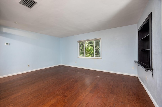 1814 NE 7th St, Gainesville, FL 32609 - unfurnished living room featuring dark wood-type flooring and baseboards