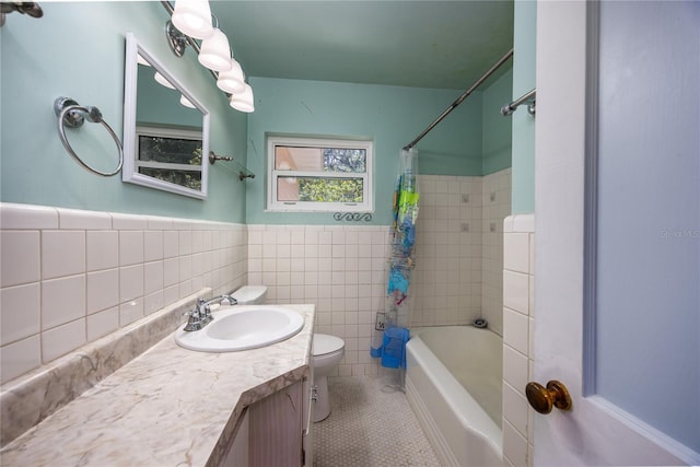 1814 NE 7th St, Gainesville, FL 32609 - bathroom featuring tile patterned flooring, shower / bath combo with shower curtain, vanity, a wainscoted wall, and tile walls