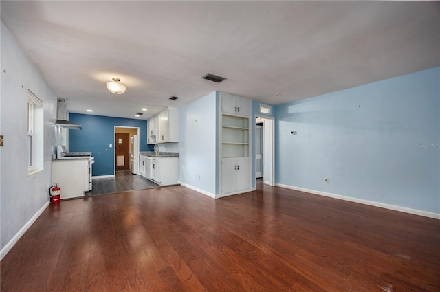 1814 NE 7th St, Gainesville, FL 32609 - unfurnished living room featuring dark wood-style floors and baseboards