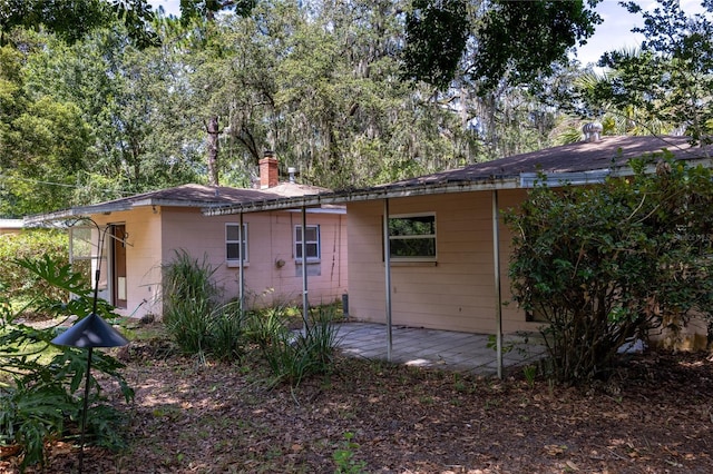 1814 NE 7th St, Gainesville, FL 32609 - view of side of home featuring a chimney and a patio