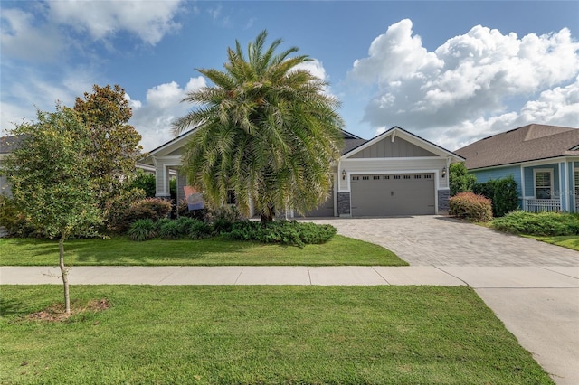 11890 SW 33rd Ln, Gainesville, FL 32608 - view of front of home with decorative driveway, a garage, a front lawn, stone siding, and board and batten siding