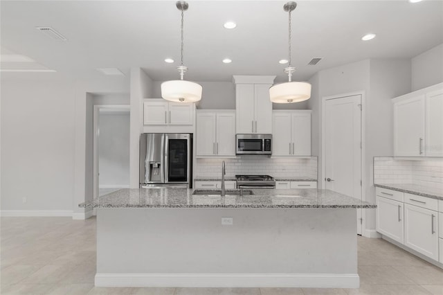 11890 SW 33rd Ln, Gainesville, FL 32608 - kitchen featuring appliances with stainless steel finishes, decorative backsplash, white cabinets, a kitchen island with sink, and recessed lighting