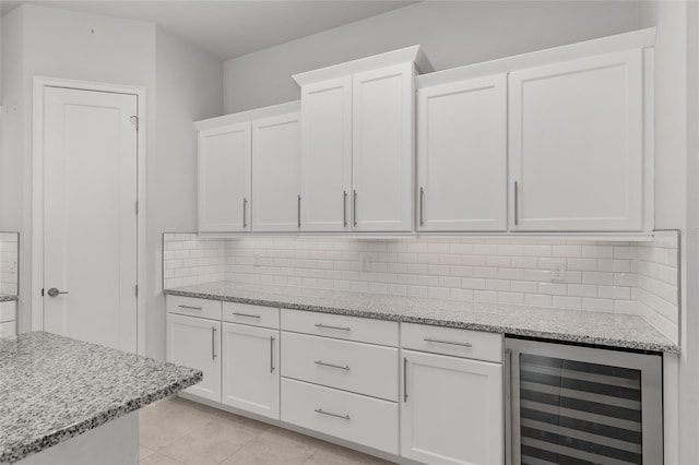 11890 SW 33rd Ln, Gainesville, FL 32608 - kitchen featuring wine cooler, white cabinets, backsplash, light stone countertops, and light tile patterned floors