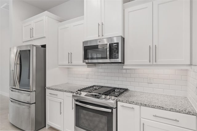 11890 SW 33rd Ln, Gainesville, FL 32608 - kitchen with stainless steel appliances, white cabinetry, light stone counters, and backsplash