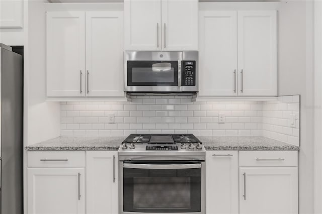 11890 SW 33rd Ln, Gainesville, FL 32608 - kitchen featuring stainless steel appliances, white cabinetry, decorative backsplash, and light stone counters
