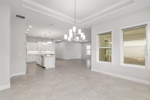 11890 SW 33rd Ln, Gainesville, FL 32608 - kitchen featuring open floor plan, a chandelier, a tray ceiling, light countertops, and white cabinets