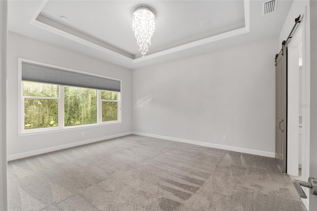 11890 SW 33rd Ln, Gainesville, FL 32608 - carpeted empty room with a barn door, a raised ceiling, and a chandelier