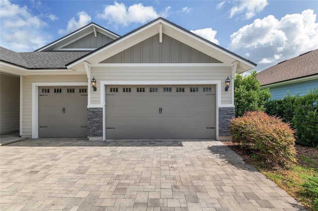11890 SW 33rd Ln, Gainesville, FL 32608 - view of front of property with board and batten siding, stone siding, a garage, driveway, and a shingled roof