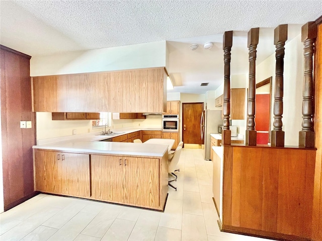 2268 NW 17th Ave, Gainesville, FL 32605 - kitchen featuring wall oven, a peninsula, a textured ceiling, freestanding refrigerator, and light countertops
